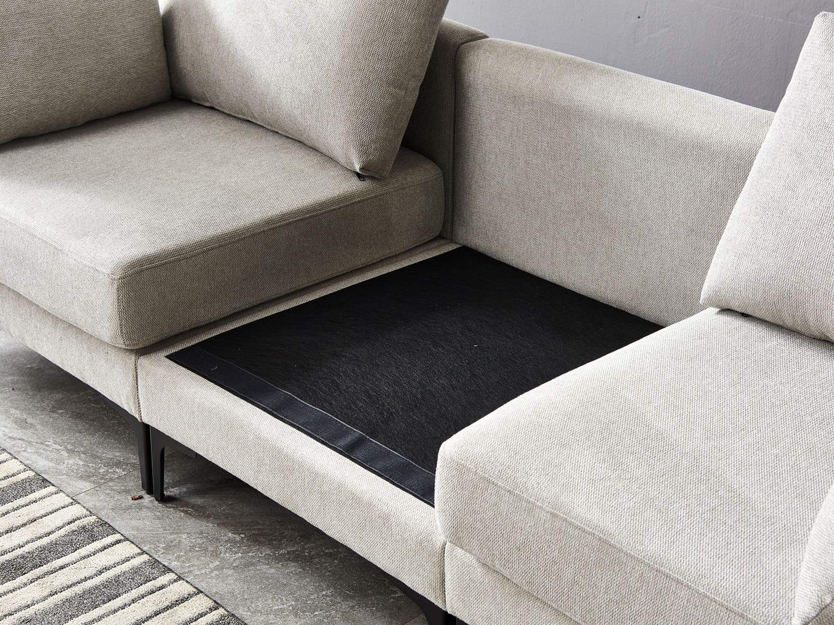 Anek three seater grey fabric sofa with metal legs and cushioned seats on modern striped rug in living room setting