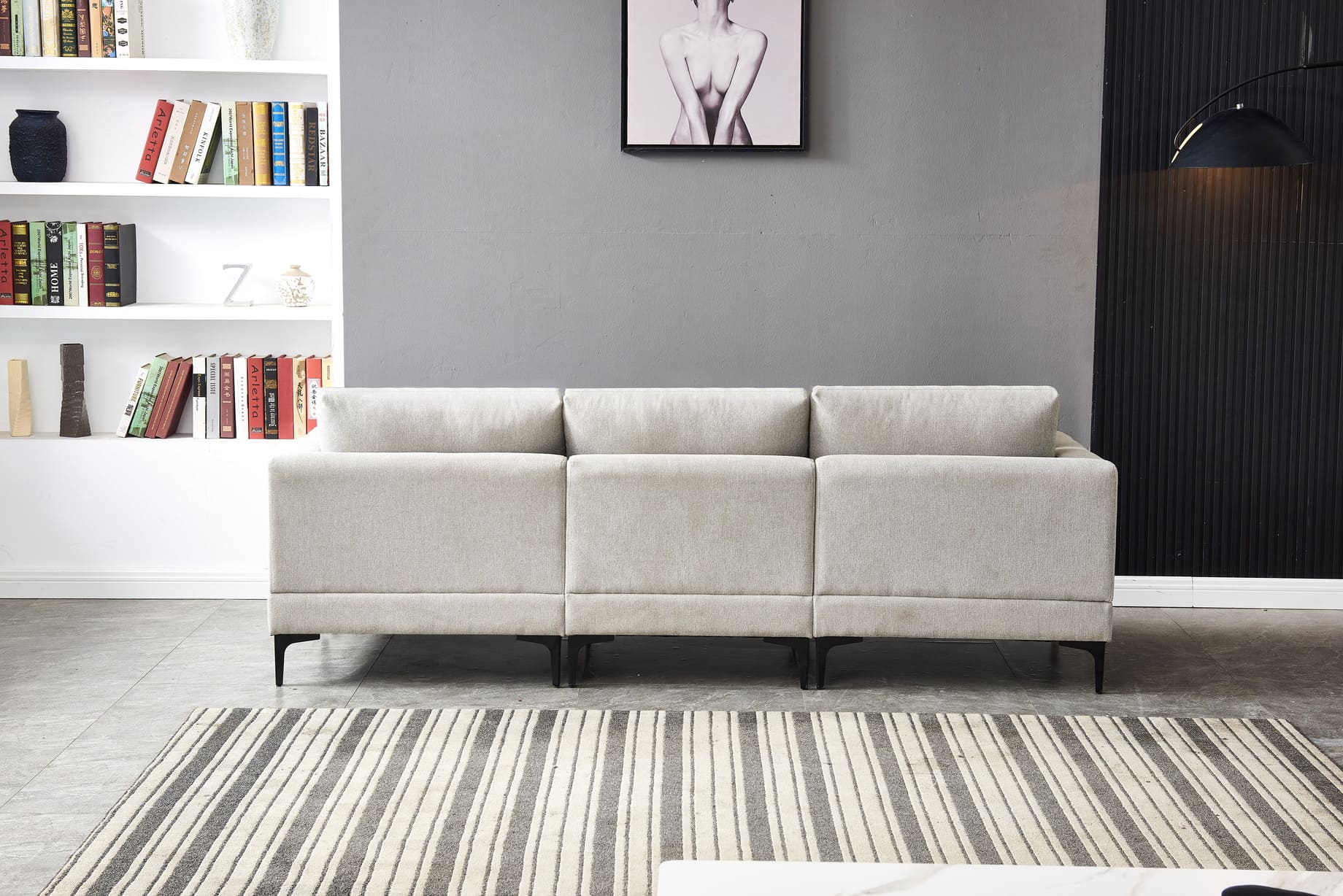 Anek Three Seater Grey Fabric Sofa with modern design on striped rug in contemporary living room with built-in bookshelf