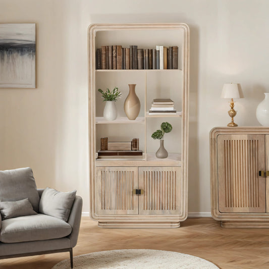 Hudson Carved Mango Wood Bookcase with decorative vases, books, and plants displayed on shelves in a modern living room setting
