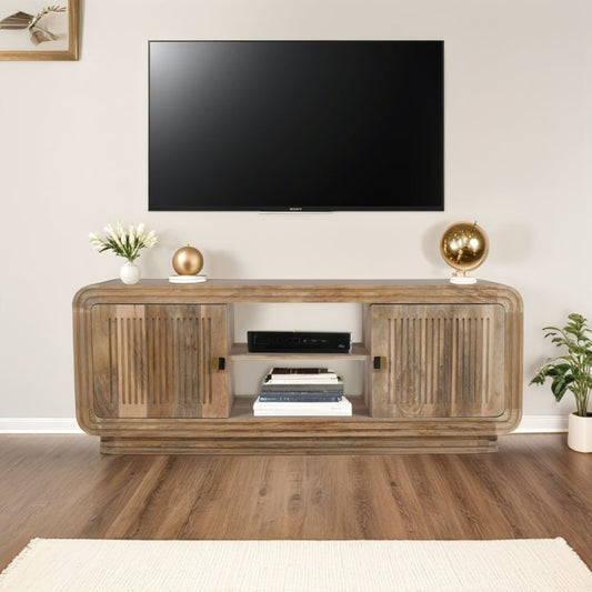 Hudson Carved Mango Wood TV Cabinet with two doors and open shelving, mounted below flat-screen TV in modern living room setting